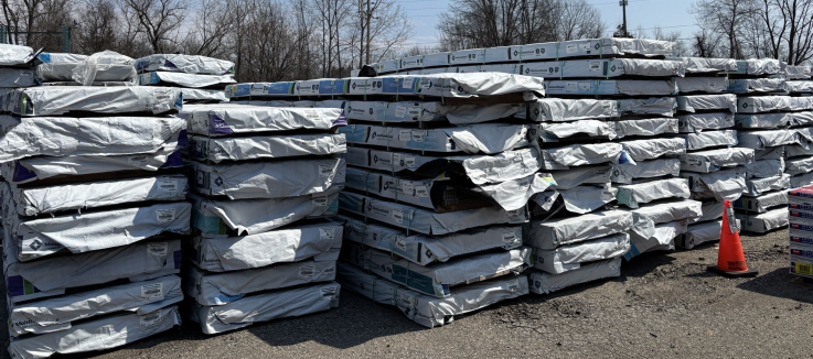 Wrapped composite decking inventory stacked in outdoor yard rows